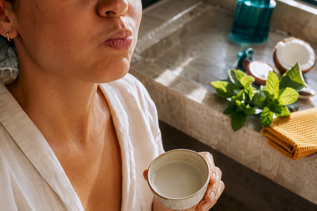 Adult practicing gentle oil pulling with coconut oil