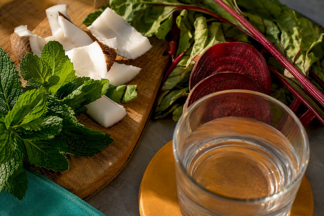 Natural ingredients beside an anonymous rinse glass
