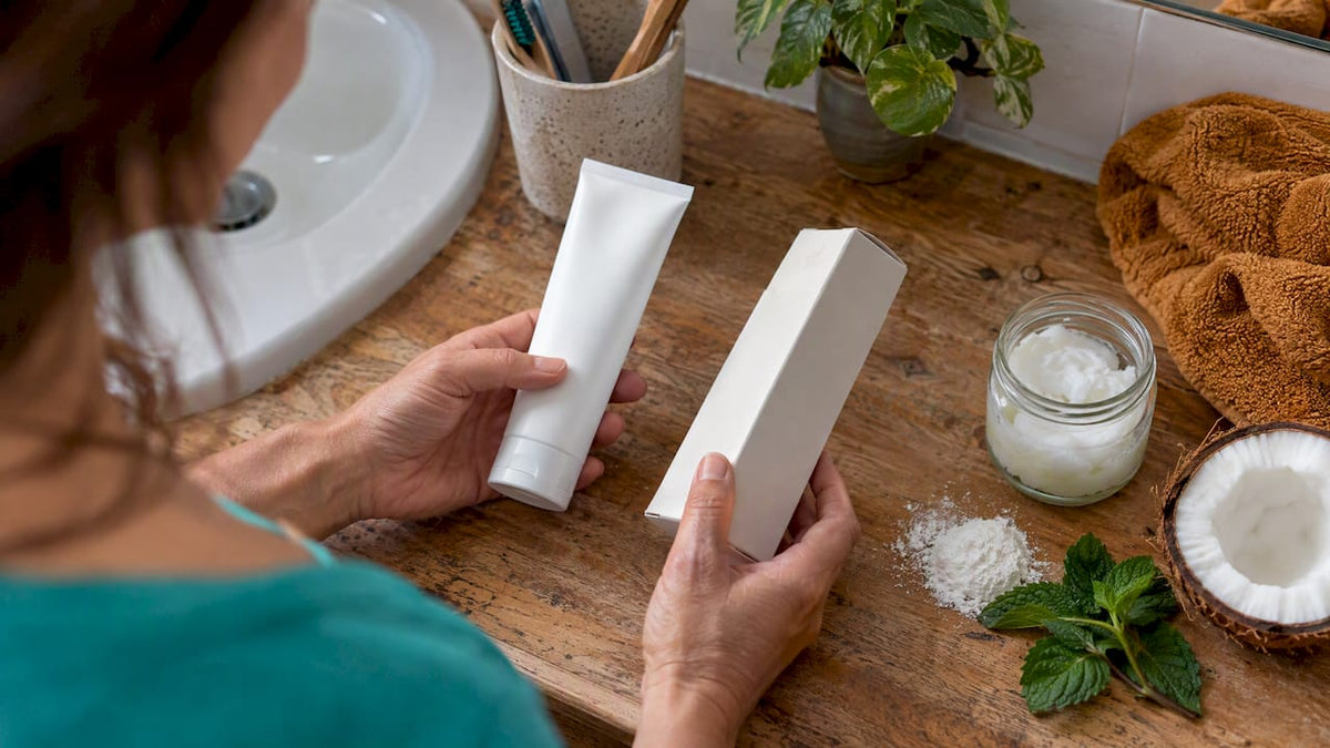 Oral care carton beside mint and coconut oil